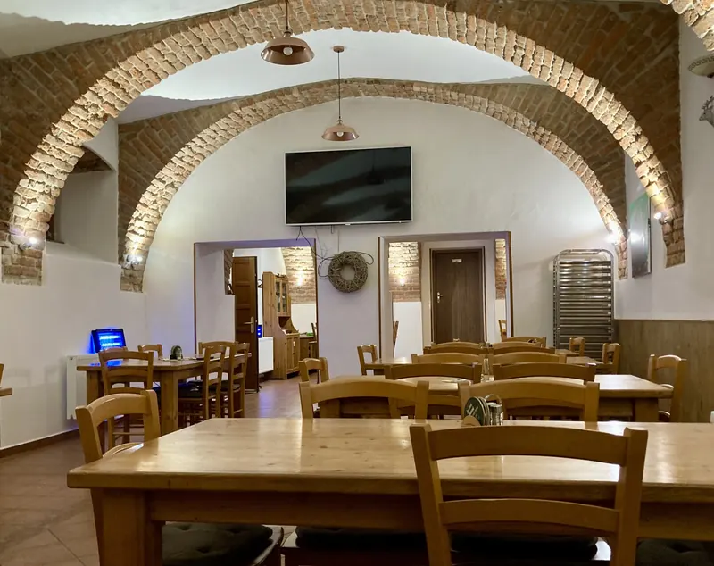 Restaurace Myslivna s cihlovými klenbami a dřevěnými stoly